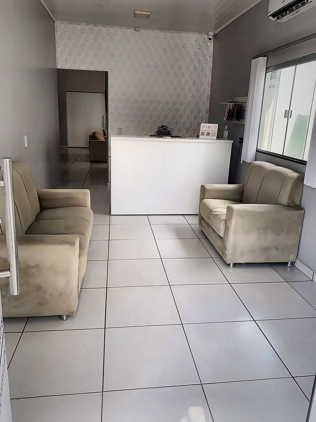 Recepção da clínica com balcão e sofás